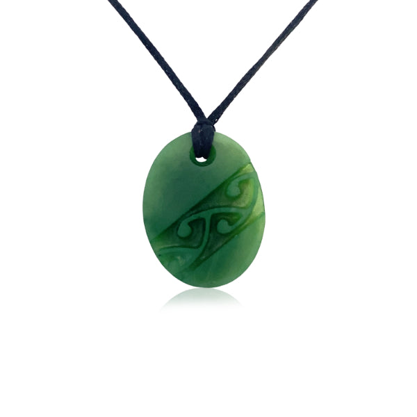 Greenstone oval with carved kowhaiwhai on slider cord