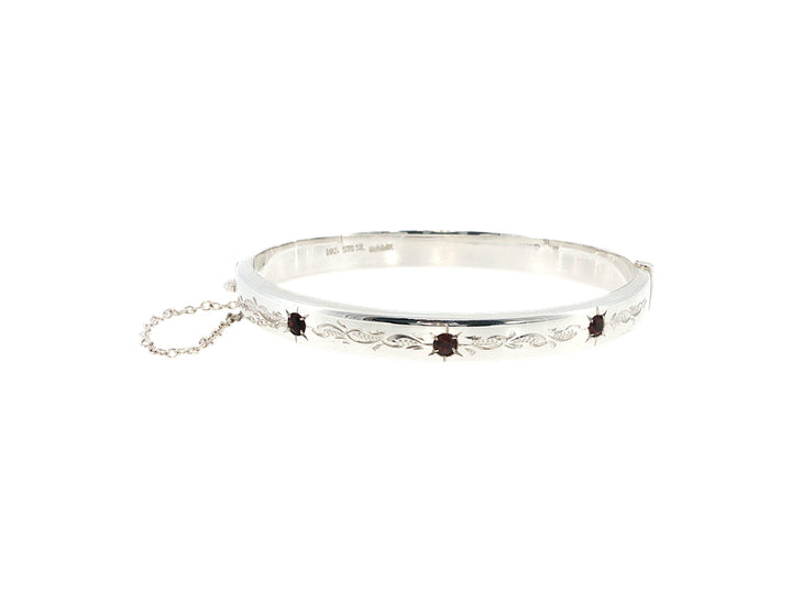 Engraved hinged bangle set with three garnets in sterling silver