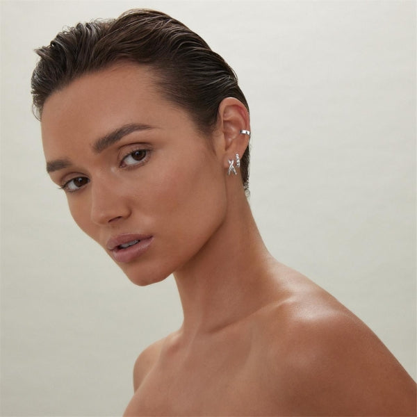Najo - Silver cross over huggie earrings