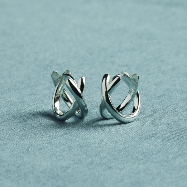 Najo - Silver cross over huggie earrings