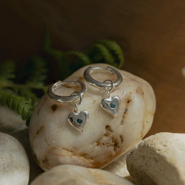 Huggie earrings with heart charm set with london blue topaz in sterling silver